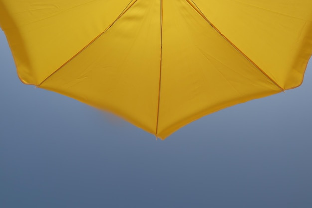 Low angle view of yellow umbrella against sky