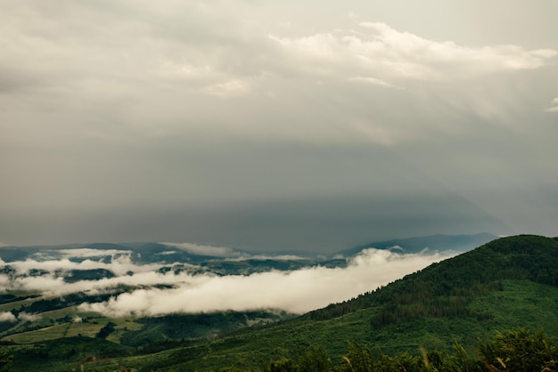 Low mist fog and stormy clouds over Carpathian mountains