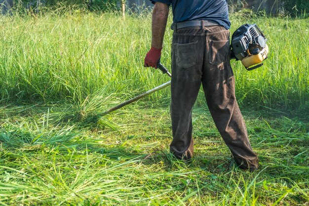 Photo low section of man cutting grass with lawn mower