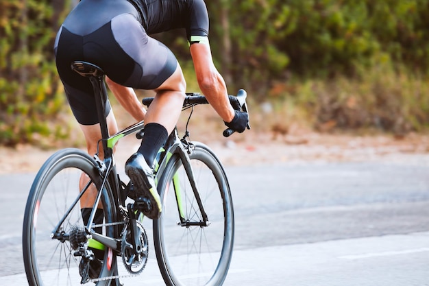 Low section of man riding bicycle on road