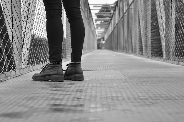 Photo low section of man standing on footbridge