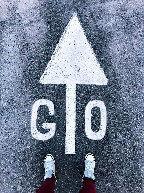 Low section of man standing on road