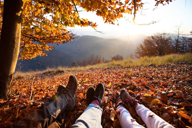 Low section of people on leaves during autumn