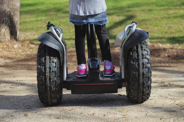 Photo low section of a person riding segway on footpath