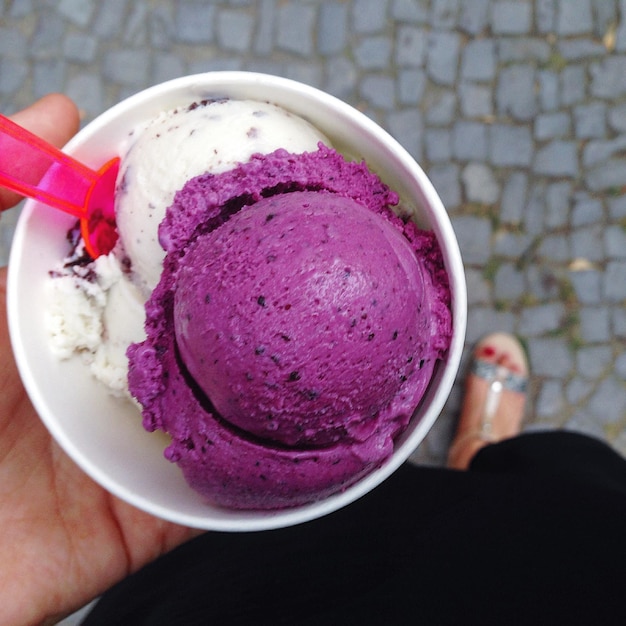 Low section of woman holding ice cream in disposable cup