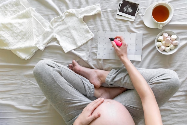 Photo low section of woman sitting on bed at home