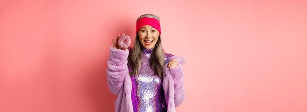 Low section of woman wearing hat against pink background