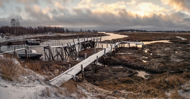 Low tide. Fishing pier in the authentic Northern village of Umba. Kola Peninsula, Russia.