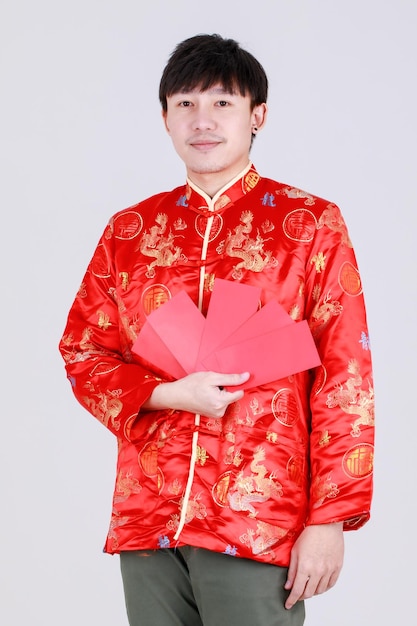 Lucky chinese man on traditional mandarin shirt smile and delight for getting cultural cash gift in red envelopes on happy holiday of prosperity celebration for lunar new year