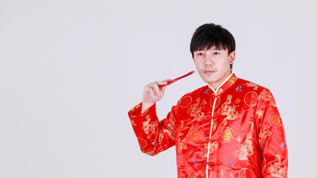 Photo lucky chinese man on traditional mandarin shirt smile and delight for getting cultural cash gift in red envelopes on happy holiday of prosperity celebration for lunar new year