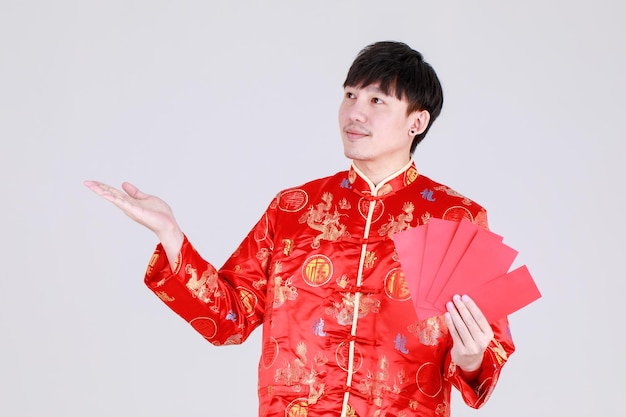 Lucky chinese man on traditional mandarin shirt smile and delight for getting cultural cash gift in red envelopes on happy holiday of prosperity celebration for lunar new year