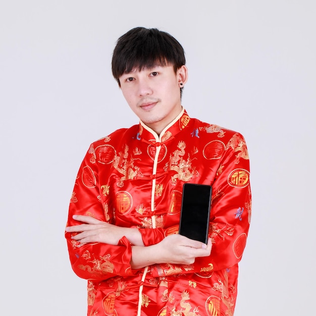 Lucky chinese man on traditional mandarin shirt smile and holding smart phone  on white background