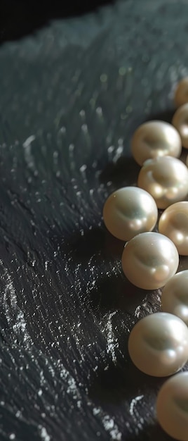 Luminous pearls against a dark matte surface creating a luxurious contrast of light and texture in a studio shot