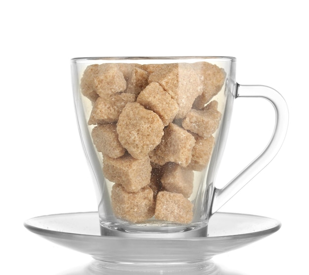 Lump brown cane sugar cubes in glass cup isolated on white