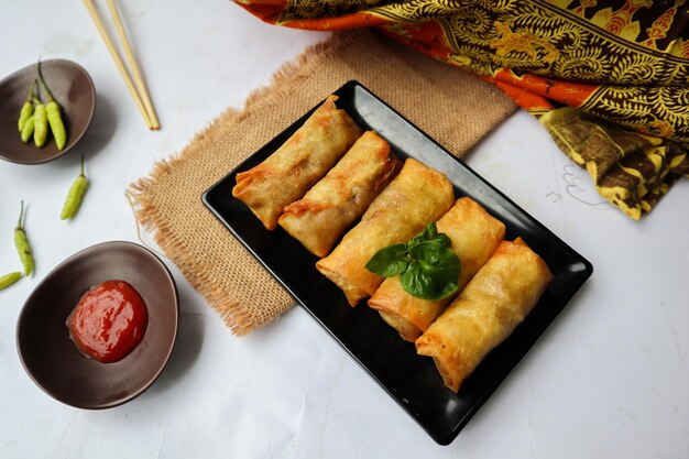 Lumpia or lunpia is traditional spring roll skin snack from Semarang Indonesia Traditional Spring rolls made eggs and chicken or shrimp stirfried bamboo shoots isolated on white background