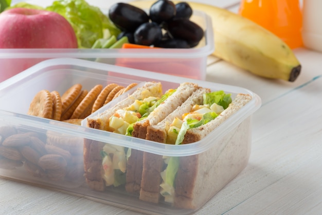 Lunch box, Egg salad with sandwich slice and almond, peanut butter cracker with fruits