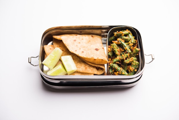 Lunch Box or Tiffin for Indian kids, includes beans vegetable sabzi with roti or chapati, selective focus