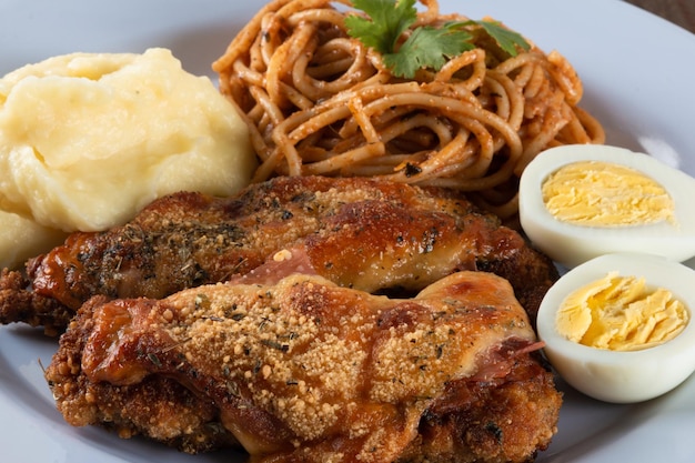 Lunch food plate Pasta with roasted chicken mashed and eggs close up view