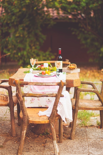 Lunch in the garden with wine and fruit. Romantic dinner in the open air. Autumn leaves of flowers. Beautiful table scrapbooking. Vintage photo.