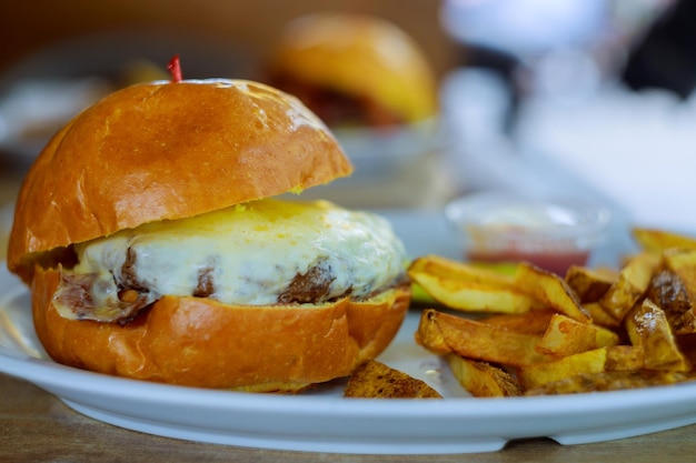 Lunch is on the table closeup with burger beef cheese bacon a french fries