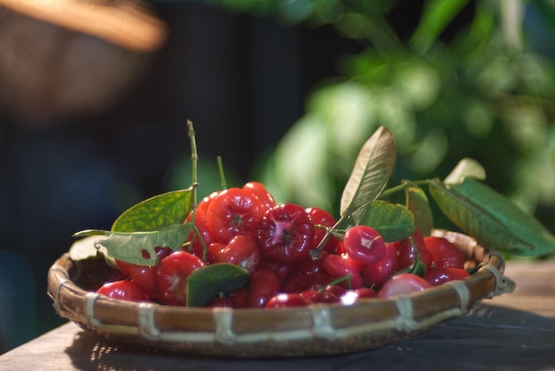 A luscious red pomerac pile in a bamboo basket with blur background