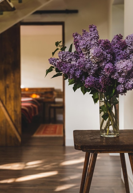 Lush lilac bouquet in a transparent glass vase in the interior