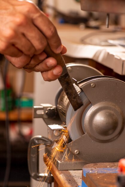 Luthier using grinder to prepare metal part