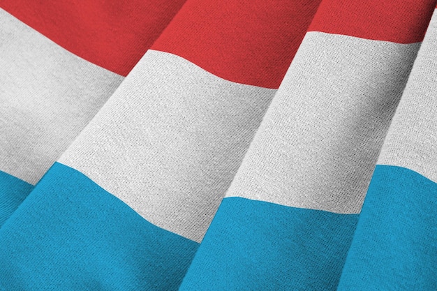 Photo luxembourg flag with big folds waving close up under the studio light indoors the official symbols and colors in banner