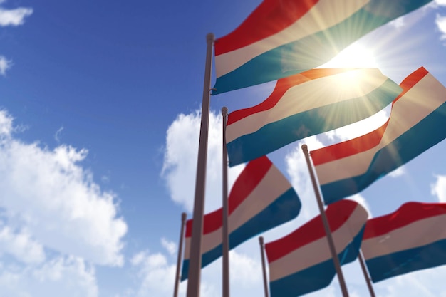 Luxembourg flags waving in the wind against a blue sky d rendering