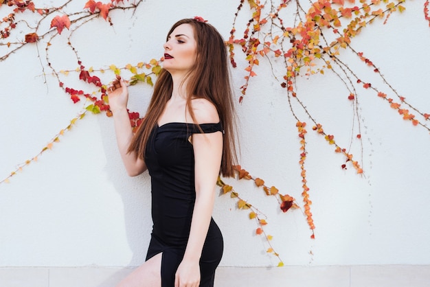 Luxurious beautiful girl in a black dress posing, enjoying a rich life and relaxing