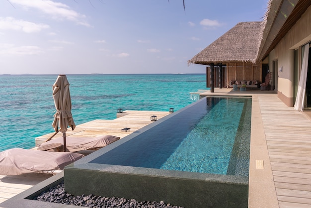 Luxurious exterior of a very expensive rich water villa in the Maldives, decorated with natural wood.