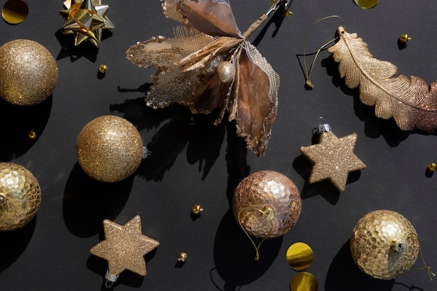 Luxurious gold Christmas flat lay pattern of various ornaments on a black background