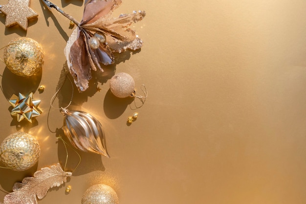 Luxurious gold Christmas flat lay of various ornaments on a golden background with copy space