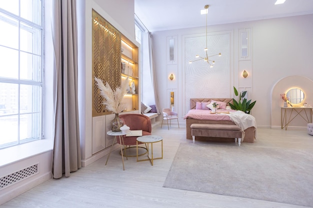 Luxurious modern bedroom interior of an expensive spacious light stylish apartment. upholstered furniture and decorative lighting, soft pastel colors and cozy atmosphere