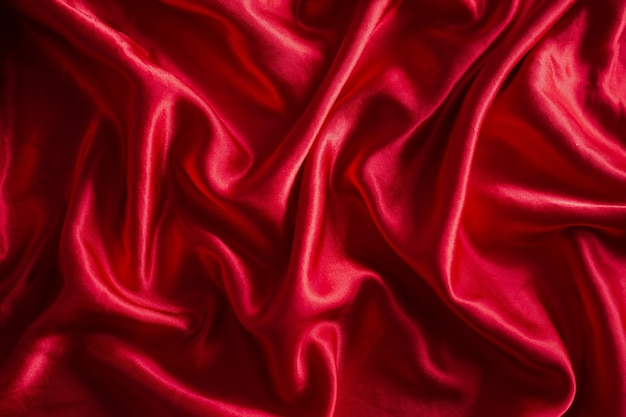 Luxurious satin red silk or fabric. Soft waves cloth abstract background.