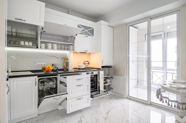 Luxurious white modern kitchen interior drawers pulled out dishwashers door open