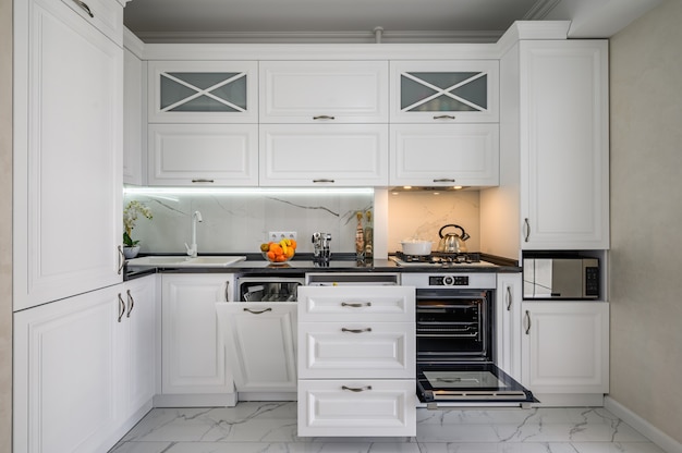 Luxurious white modern kitchen interior drawers pulled out dishwashers door open