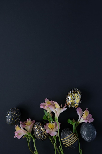 Luxury black easter eggs with gold pattern and pink flowers on black background. Happy Easter