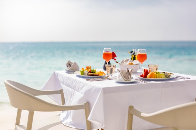 Luxury breakfast table with food for two with beautiful tropical sea view background. Morning couple