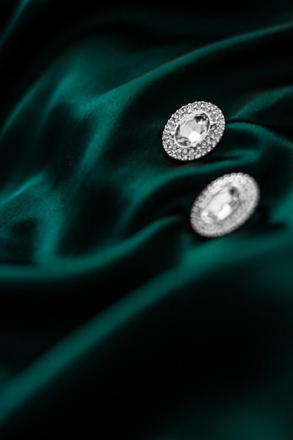 Luxury diamond earrings on dark emerald green silk holiday glamour jewelery present