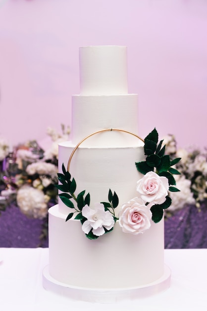 Luxury four-tier white cake with flowers, wedding dessert