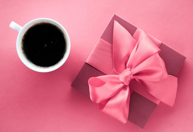 Luxury gift box and coffee cup on pink background flatlay design for romantic holiday morning surprise