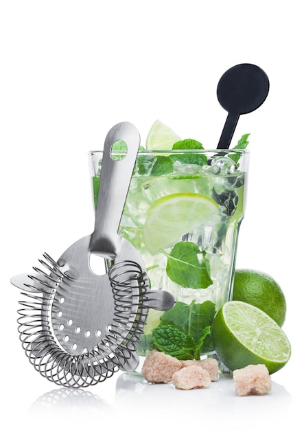 Luxury glass of Mojito summer alcoholic cocktail with ice cubes mint and lime on white background with cane sugar and raw lime with steel strainer