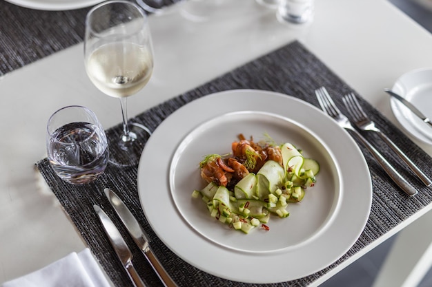 Luxury gourmet appetizer of cucumber rolls with shrimps closeup vegetables on elegant white plate