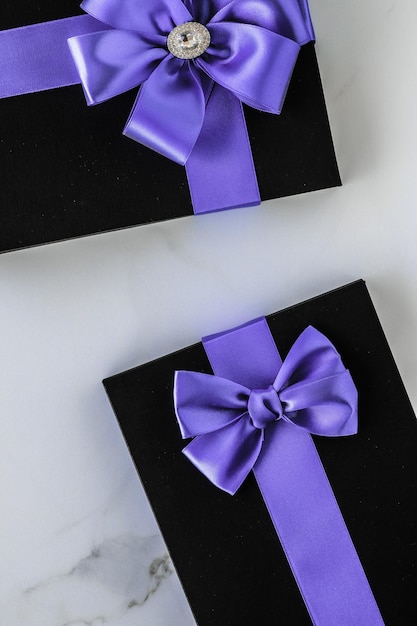 Luxury holiday gifts with lavender silk ribbon and bow on marble background