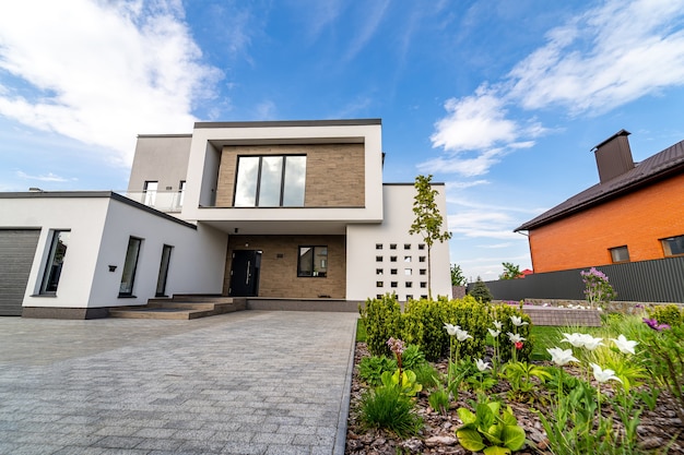 Luxury house with garage. Blue sky above. Nobody in the yard. Modern architecture. Cozy and modern house. Modern architecture.