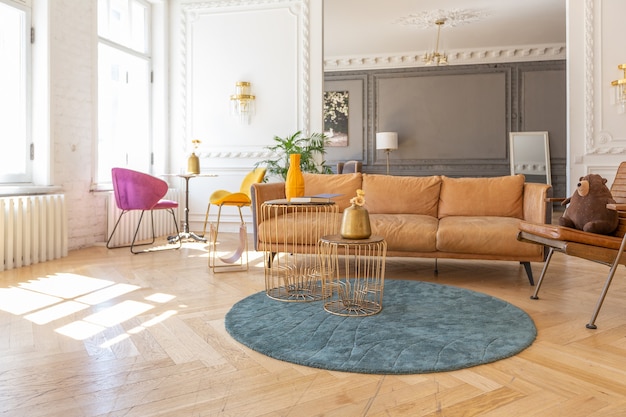 Luxury interior of a spacious apartment in an old 19th century historical house with modern furniture. high ceiling and walls are decorated with stucco