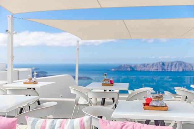 Luxury outdoor restaurant sea view. Elegant white minimalist decorations under sunlight Santorini