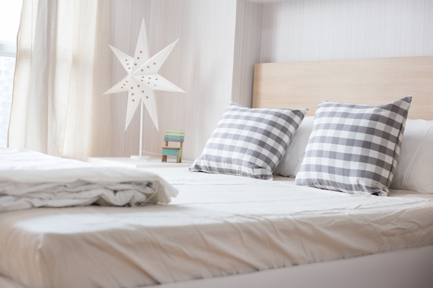 Luxury pillows on white bed in bedroom