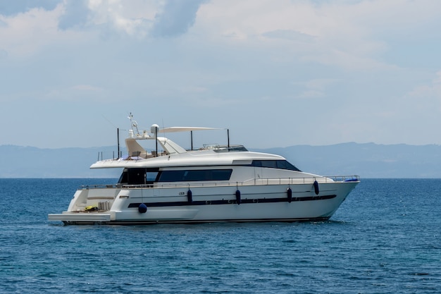 Luxury private motor yacht under way on tropical sea with bow wave